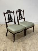 A pair of well carved late Victorian mahogany bedroom chairs, with upholstered seats, on turned
