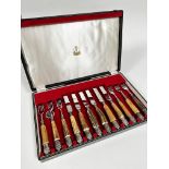 A set of six pairs of horn handled Epns steak knives and forks in original fitted case marked Samuel