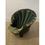 An unusual late 19th/ early 20th century club chair, formed as a shell, raised turned front supports