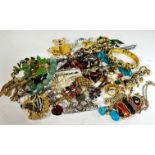 A collection of costume jewellery including enamelled fish pendants, a paste set teddy bear, an