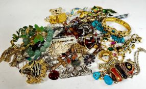 A collection of costume jewellery including enamelled fish pendants, a paste set teddy bear, an