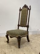 A Victorian rosewood nursing chair, floral carved pediment and spiral turned pilasters, serpentine