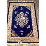 A Chinese washed wool pile rug, the deep blue field with dragon medallion and floral spandrels