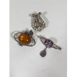 An amethyst set white metal bar brooch with pear cut drop, together with two white metal brooches (