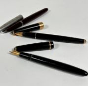 Two black Parker fountain pens, one with gold band cover and tip, a maroon stainless steel mounted