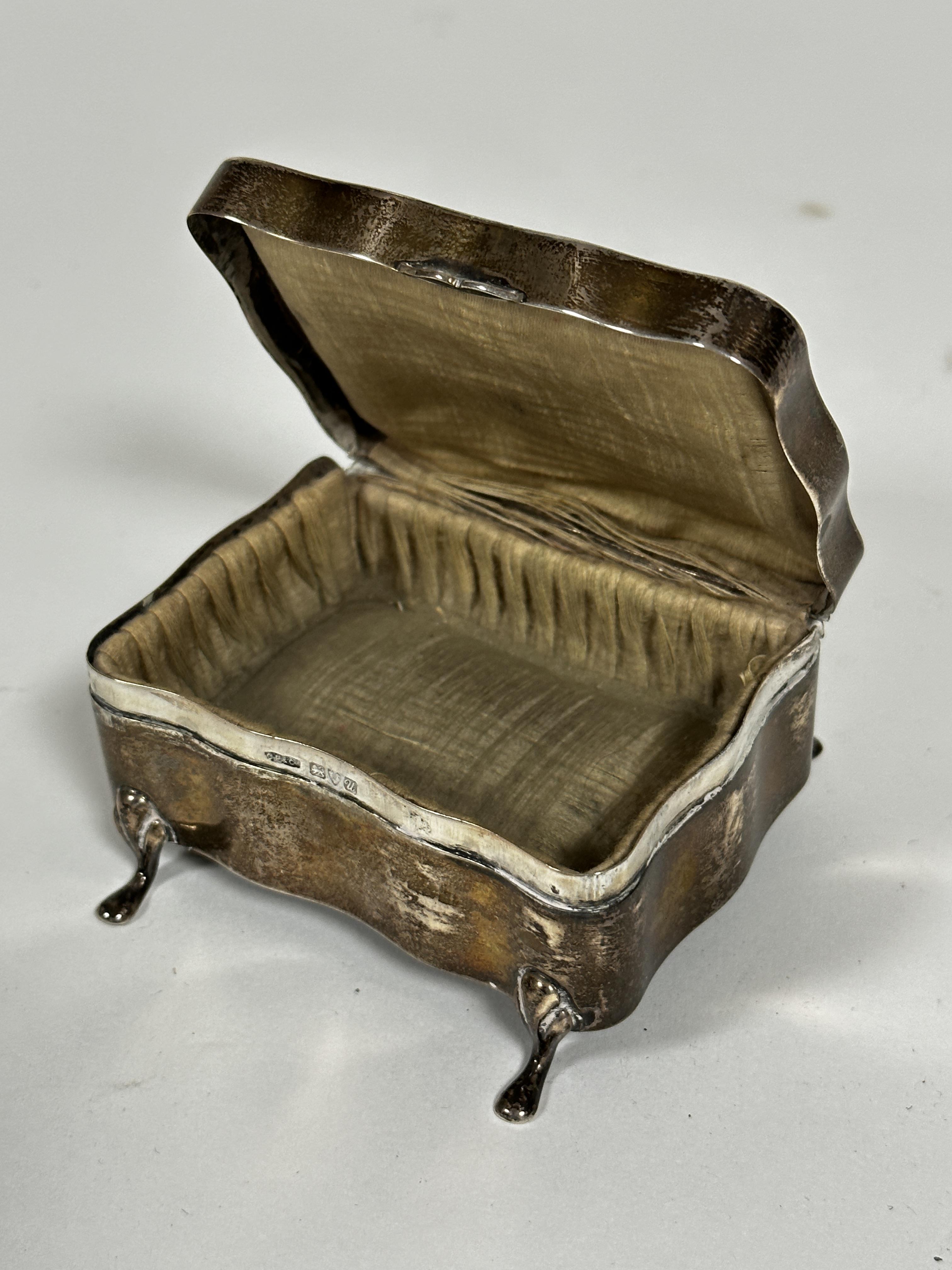A Chester silver serpentine top miniature jewellery box with hinged cover, raised on velvet lined