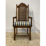 A distressed cherry wood high back carver dining chair of 17th century design, with cane back,