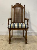 A distressed cherry wood high back carver dining chair of 17th century design, with cane back,