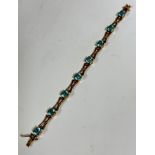 A 9ct gold link articulated line bracelet with X shaped links, set eight blue zircons in claw