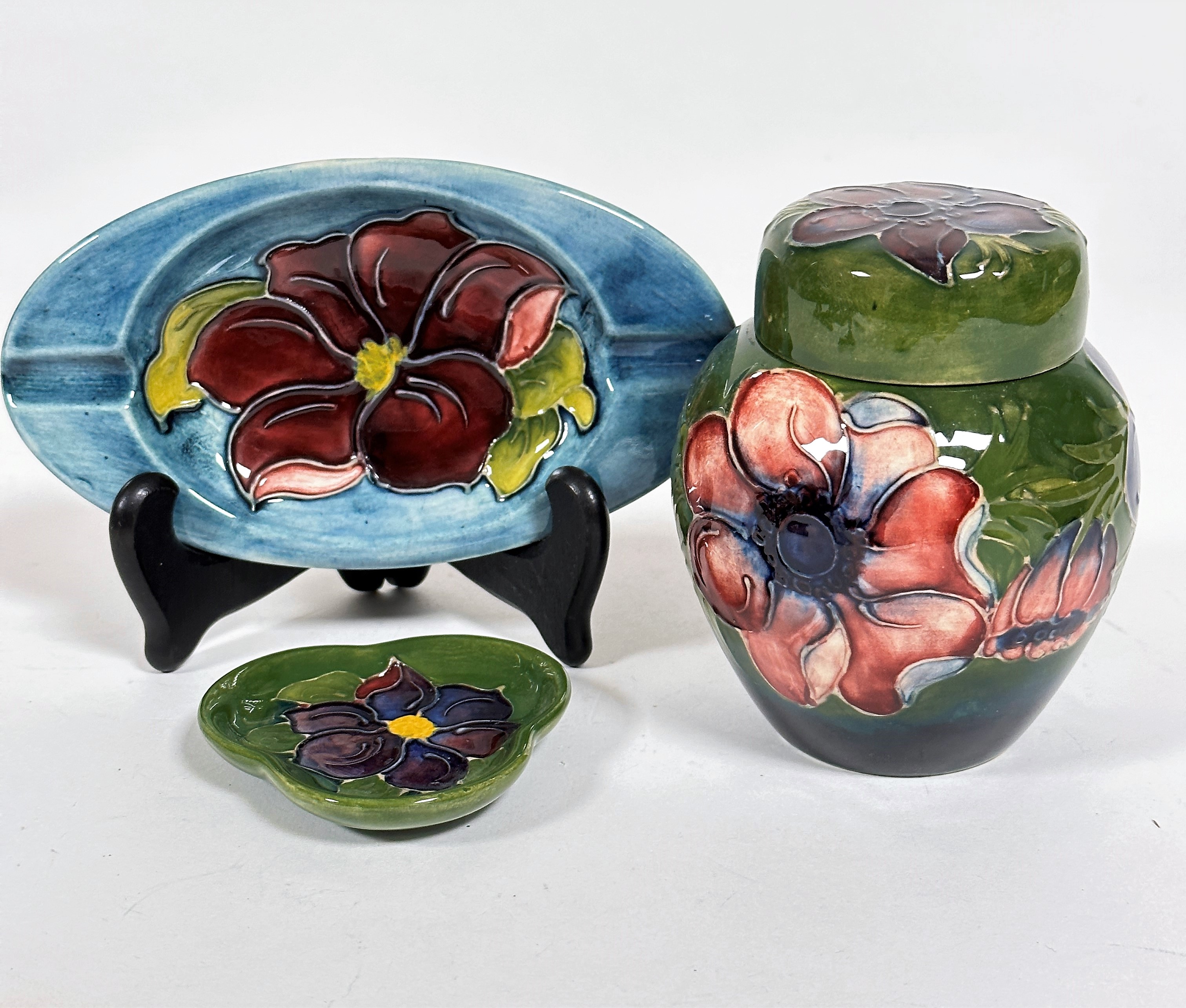 A Moorcroft miniature ginger jar decorated with anemone design, with green to blue ground,