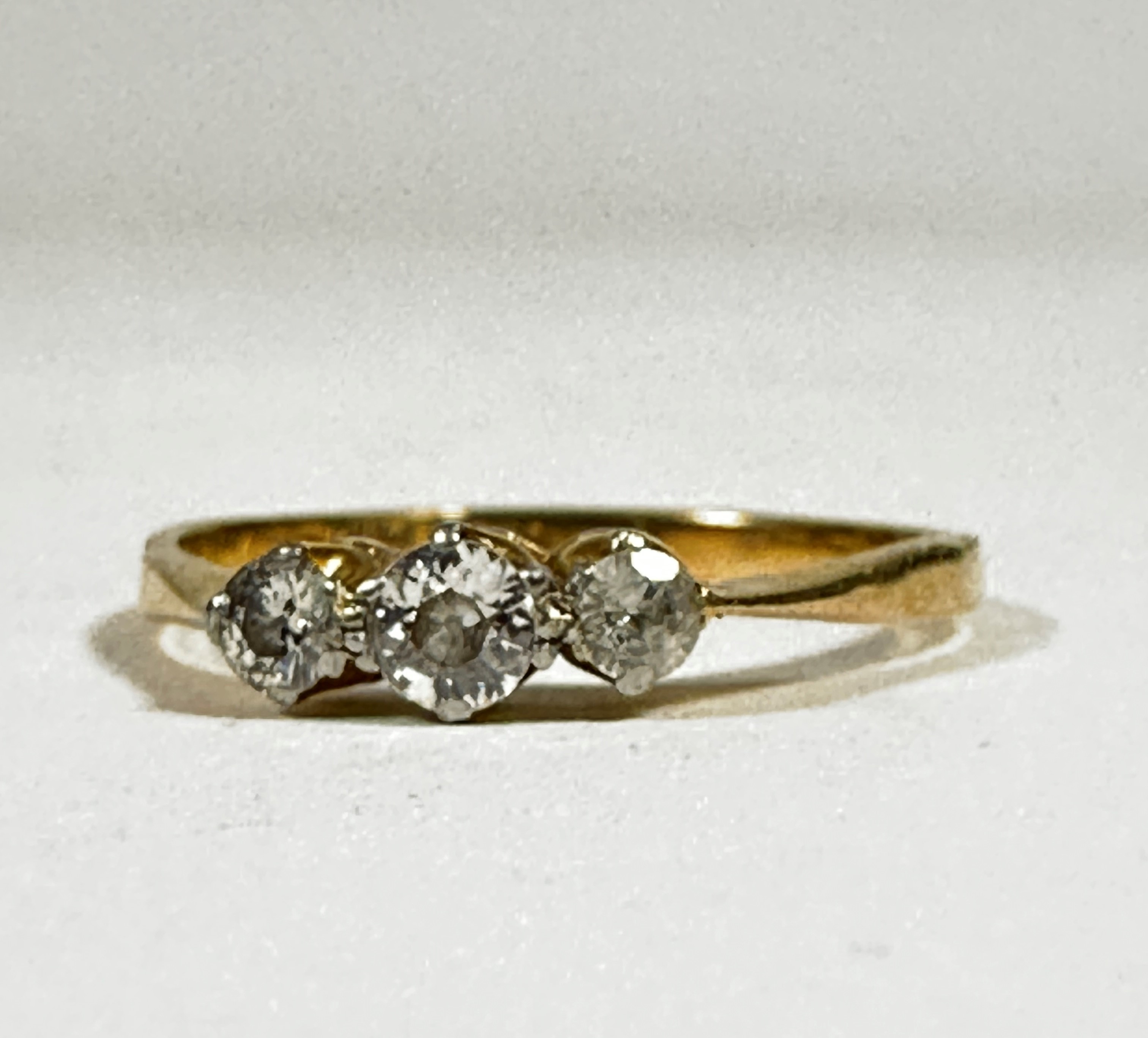 An 18ct gold and platinum set three stone graduated diamond ring, set in claw setting (centre