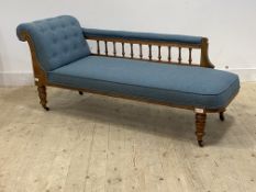 A late Victorian walnut framed chaise longue, upholstered in buttoned blue wool, with arm rest on