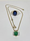 An oval cut blue stone ring, on 9ct band, together with a green stone pendant necklace on yellow