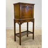 A 1930's oak secretaire on stand, the fall front revealing fitted interior, the base fitted with