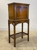 A 1930's oak secretaire on stand, the fall front revealing fitted interior, the base fitted with