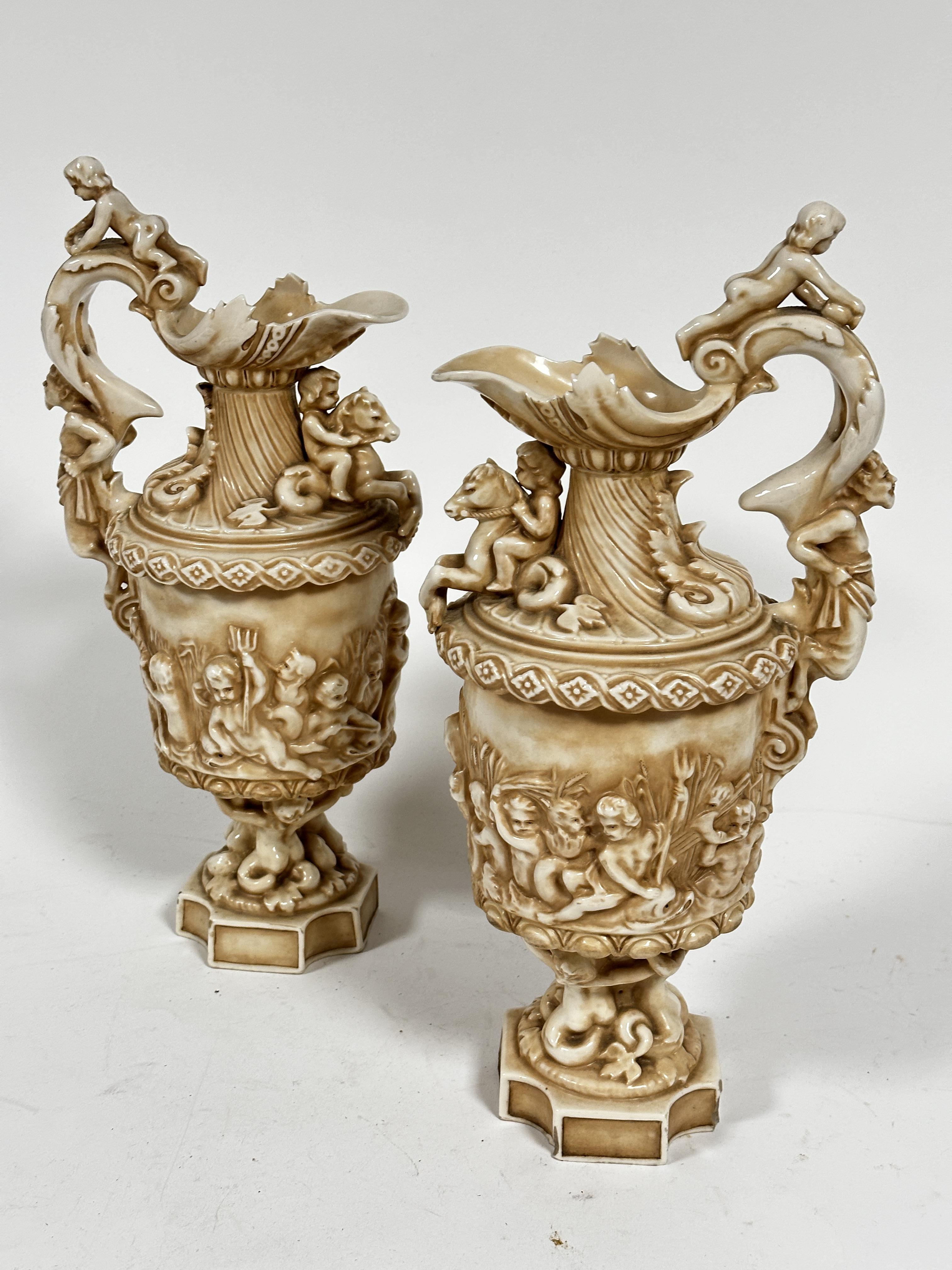 A pair of late 19thc Rudolstadt Straus & Sohne ewers, the handles mounted with cherubs with mask