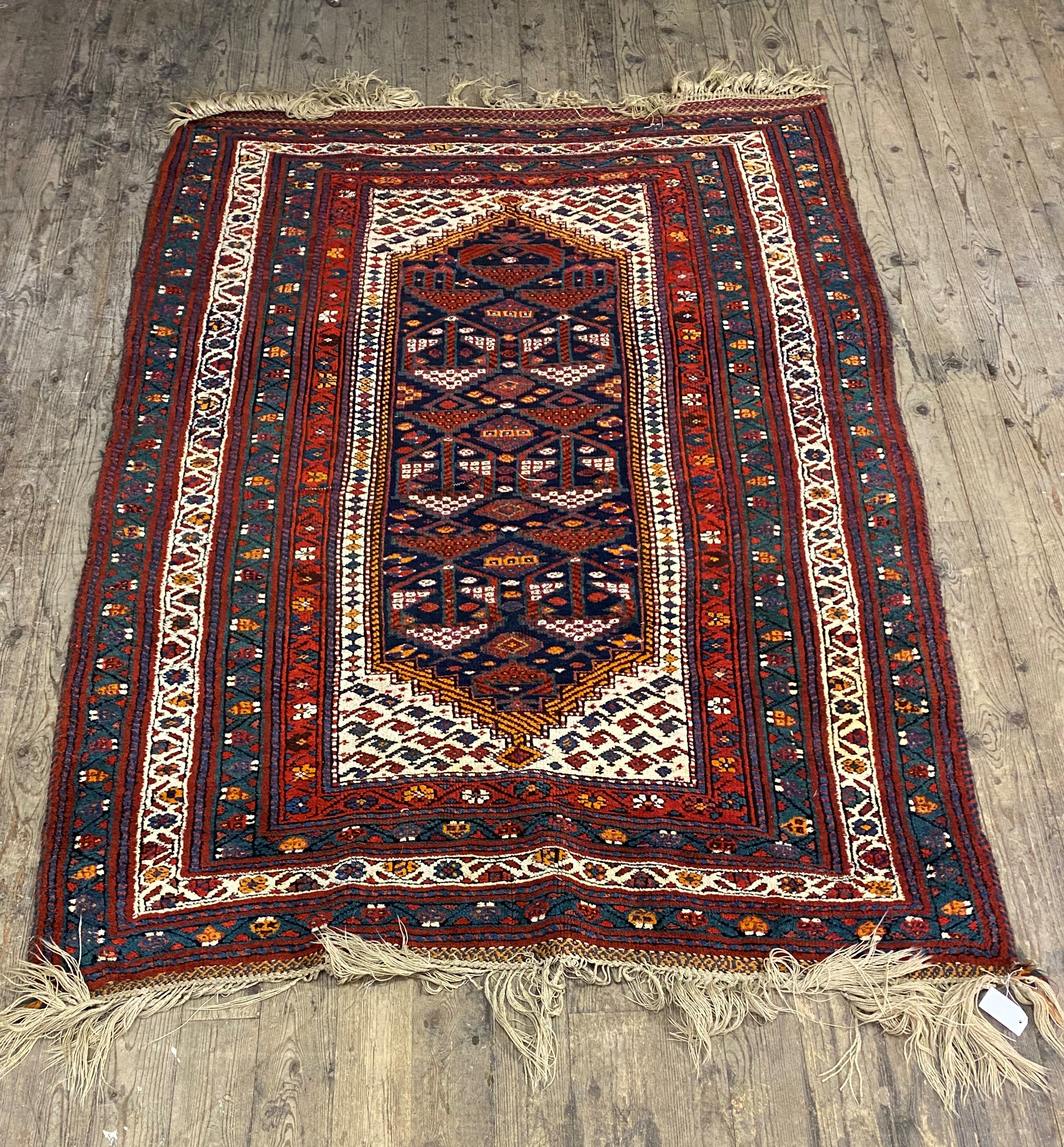 A hand knotted Caucasian rug, of all over geometric design with multiple guard stripes to border