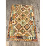 A Chobi kilim rug of typical design and palette 153cm x 57cm