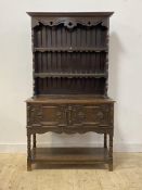 A late 19th/ early 20th century oak dresser, the two height plate rack over two geometric panelled