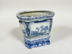 A modern Chinese blue and white oval panel sided plant pot complete with stand with stylised