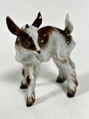An Italian ceramic model of a kid goat, decorated with polychrome enamels, (h 11.5cm x 9cm) signed
