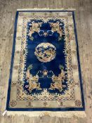 A Chinese washed wool pile rug, the blue ground with medallion within an ivory border 152cm x 270cm