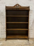 A 1930s oak open water fall bookcase, pierced ledge back over three shelves, panel end supports,