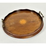 An Edwardian mahogany circular two handled tea tray with scalloped top with central satinwood inlaid