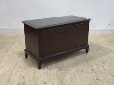 A Stag Minstrel blanket box with hinged lid opening to a plain interior over panelled front and