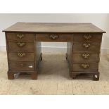 An early 19th century mahogany partners desk, each side fitted with one long and seven short