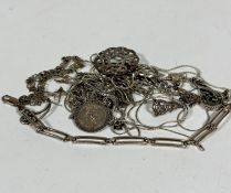 A collection of silver and white metal chains including a silver link bracelet, a floral style