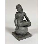 Evelyn Cheape, (1957) a plaster cast of a naked figure seated on ball on square moulded base, with