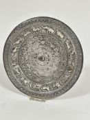 An Indian white metal chased circular dish with Boteh scrolling border enclosing an inner border