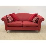 A traditional two seat sofa, upholstered in red herringbone fabric, raised on turned front