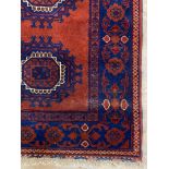 A hand knotted Bokhara runner rug, the red field with nine guls within a deep blue border 365cm x