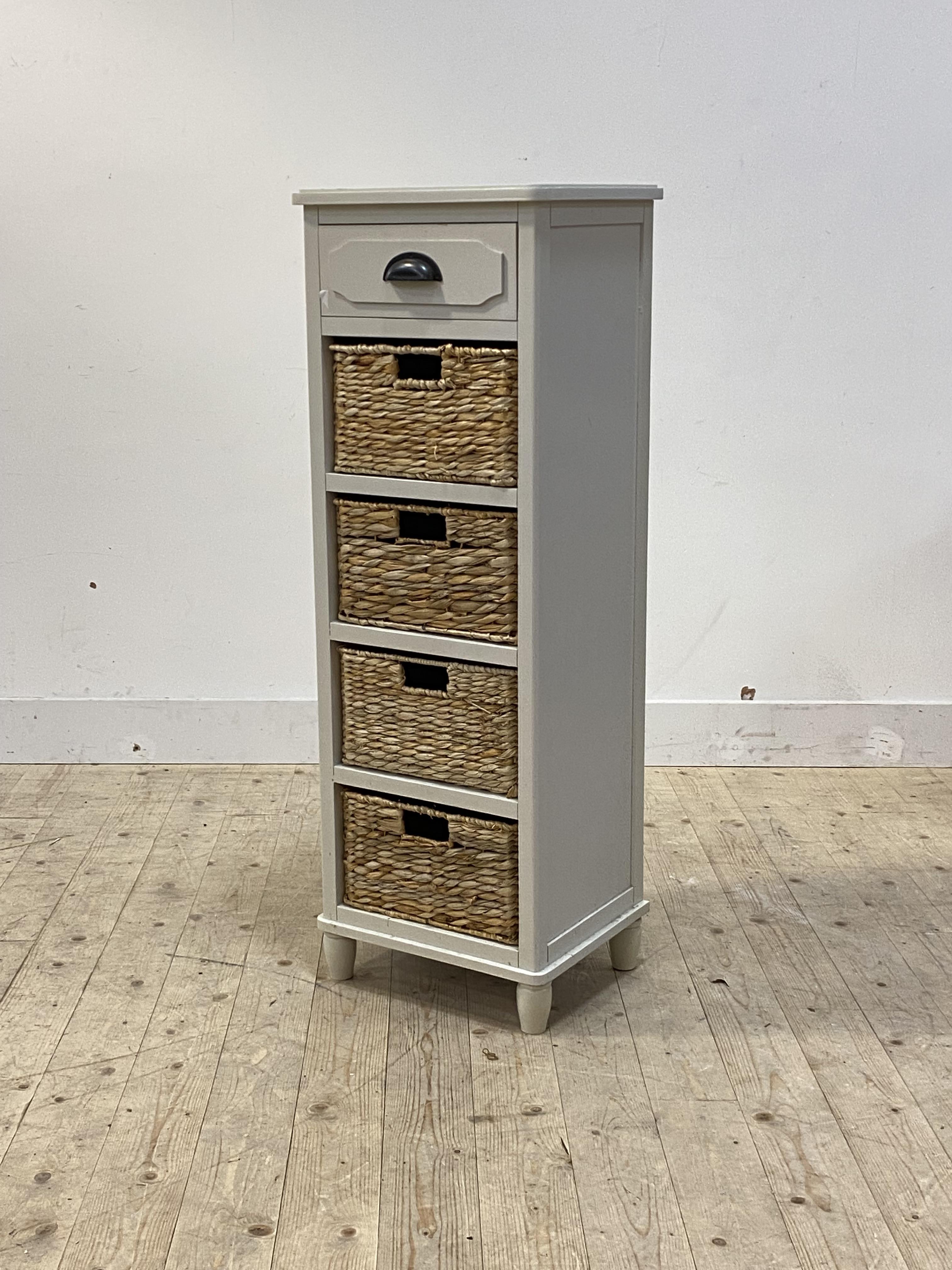 A contemporary white storage unit, with drawer over four baskets, turned supports, (A/F) H116cm,