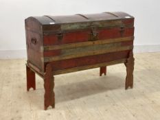 An early 20th century wooden bound tin dome top trunk, the top opening to a paper lined interior,