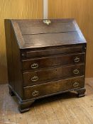 A George II oak bureau, mid 18th century, the fall front revealing a well fitted but tired interior,