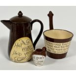 A group of pottery motto ware including a hot milk jug with inscription Her Water Help Yersel,