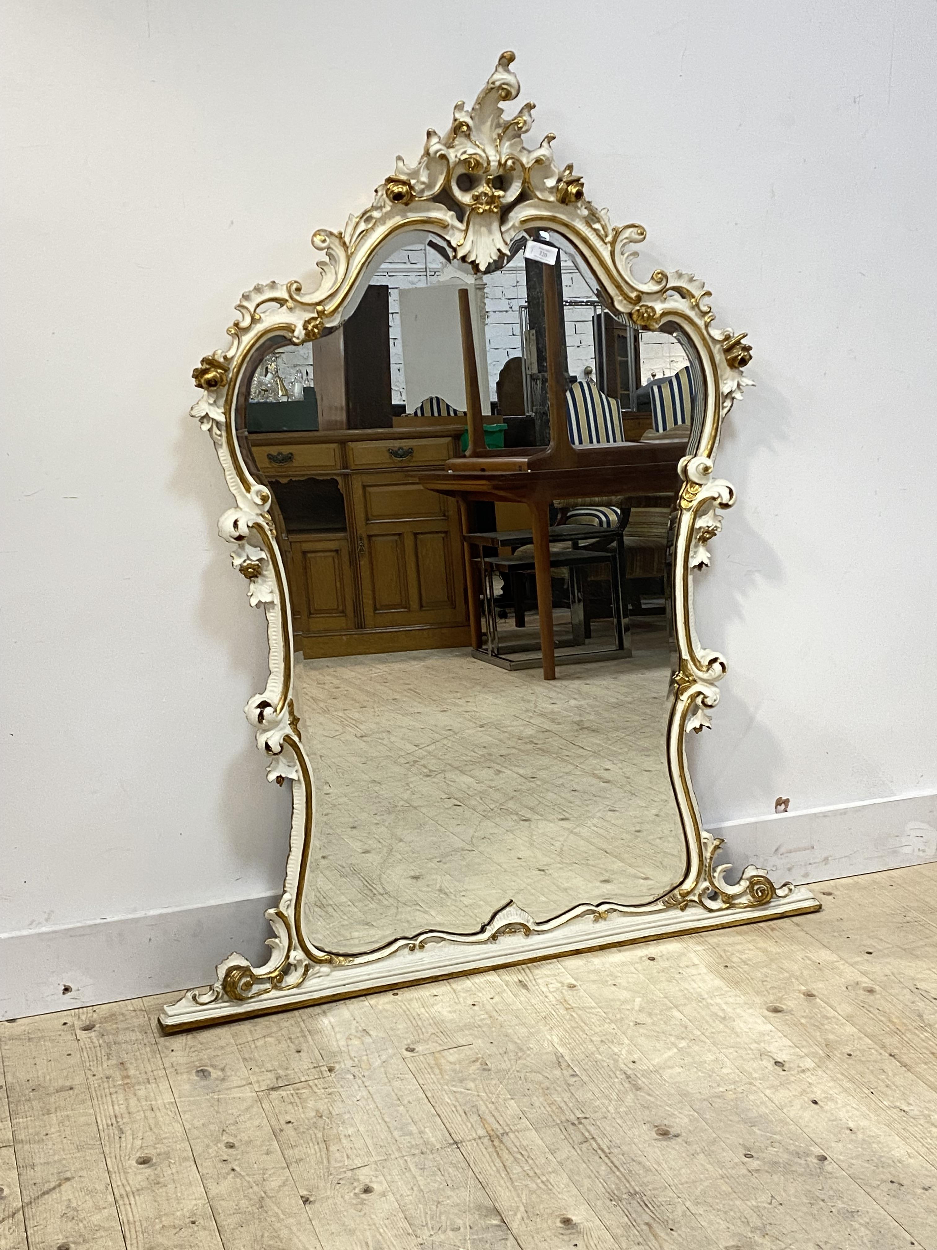 A parcel gilt composition framed Rococo style over mantel mirror, the frame of 'C' scrolled acanthus