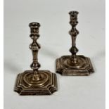 A pair of London 1896 silver taper candlesticks of Georgian design with baluster stems, on stepped
