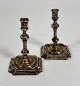 A pair of London 1896 silver taper candlesticks of Georgian design with baluster stems, on stepped
