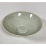 A Chinese Qing style celadon glazed bowl decorated with stylised fish and scrolling wave interior