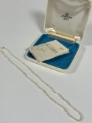 A graduated cultured pearl necklace with 9ct gold barrel fastening, (L:24cm) with original