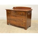 An early 20th century mahogany ledgeback chest fitted with three graduated drawers, raised on