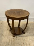 An Art Deco walnut veneered lamp table, the circular top over bowed stretchers united by under tier,