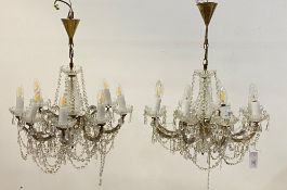 A pair of Ventitan style cut glass and brass chandeliers, the central column issuing eight