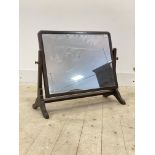 A 1930's mahogany framed vanity mirror, the rectangular plate swivelling between square tapered