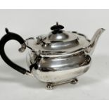 A Sheffield silver oval teapot with scalloped top and ebony handle and knop, with engraved