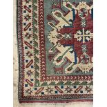 A Turkish hand knotted rug, the teal ground with geometric medallion within an ivory border 185cm